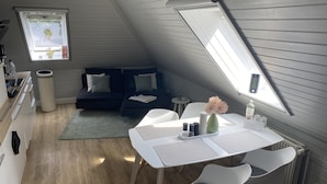 En moderne loftlejlighed med spiseplads, køkken og hyggelig opholdsstue.