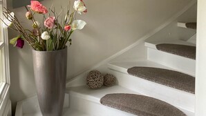En trappe med en vase blomster på repos.