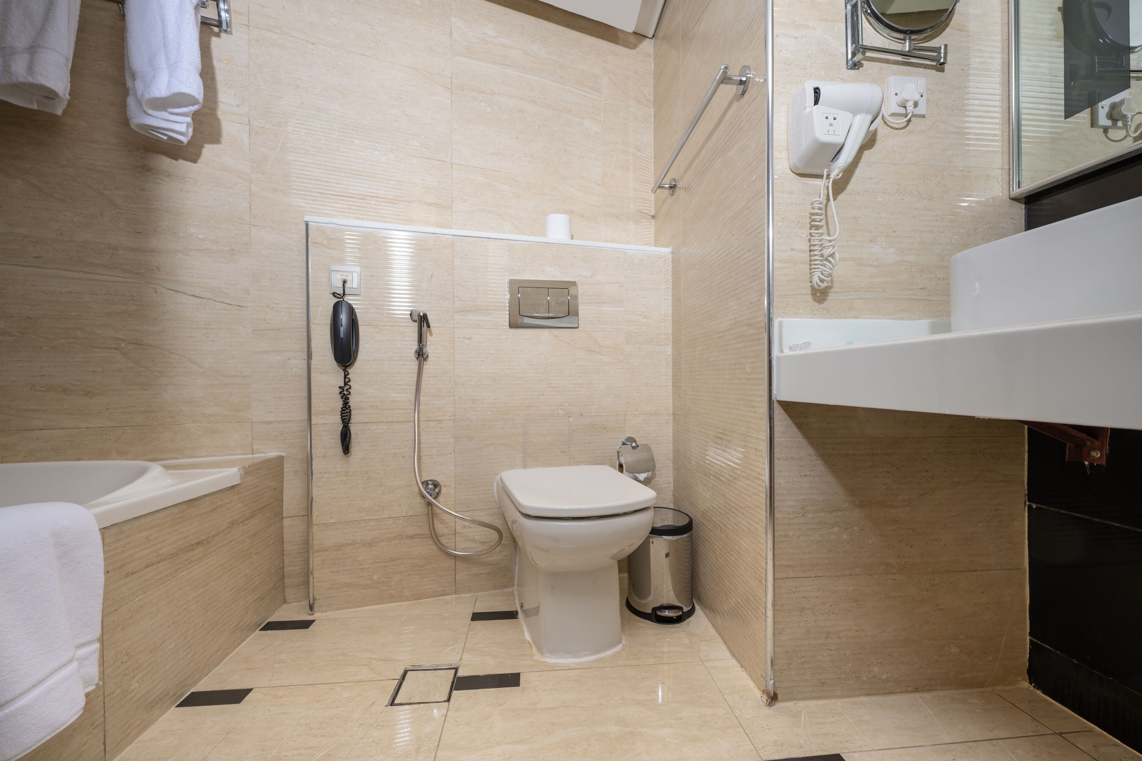 Ein modernes Badezimmer mit Badewanne, Toilette und Dusche.