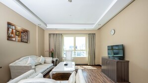 Ein modernes Wohnzimmer mit einer Couch, einem Couchtisch, einem Fernseher und einem Essbereich.
