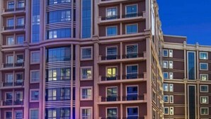 Ein mehrstöckiges Hotel mit modernem architektonischen Design, das Balkone und große Fenster aufweist.
