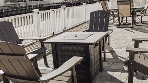 An outdoor patio area with Adirondack chairs, a table, and a grill. - Beautiful waterfront summer getaway-7 minutes to beach! (Stafford Township)