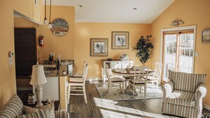 A dining area with a table and chairs, a sofa, and a lamp. - Beautiful waterfront summer getaway-7 minutes to beach! (Stafford Township)