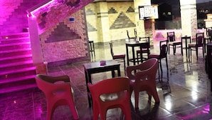 A restaurant with a staircase and seating area.
