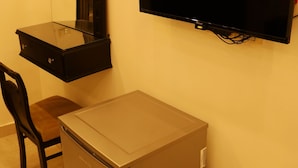 A compact kitchenette with a refrigerator, a small table, and a chair.