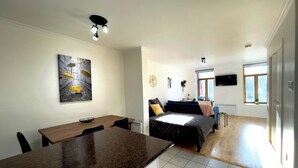 A modern apartment with a dining area, a bed, and a TV. - Amazing Loft in Saint-Roch (Québec)