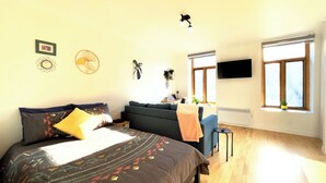 A bedroom with a bed, a sofa, a TV, and a window. - Amazing Loft in Saint-Roch (Québec)