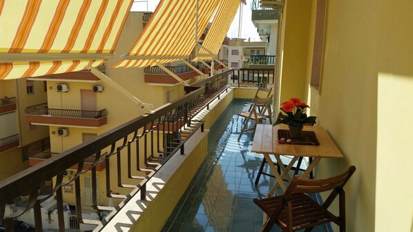 A corridor with a tiled floor, striped awnings, and a staircase.