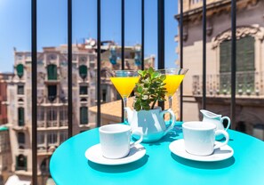 A table with two white cups and a white pitcher, set against a turquoise tablecloth.