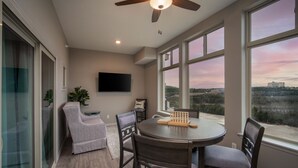 A modern dining area with a round table, dark chairs, and a ceiling fan. - Stylish 4BR Majestic Retreat • Stunning Views of Table Rock Lake! (Branson)