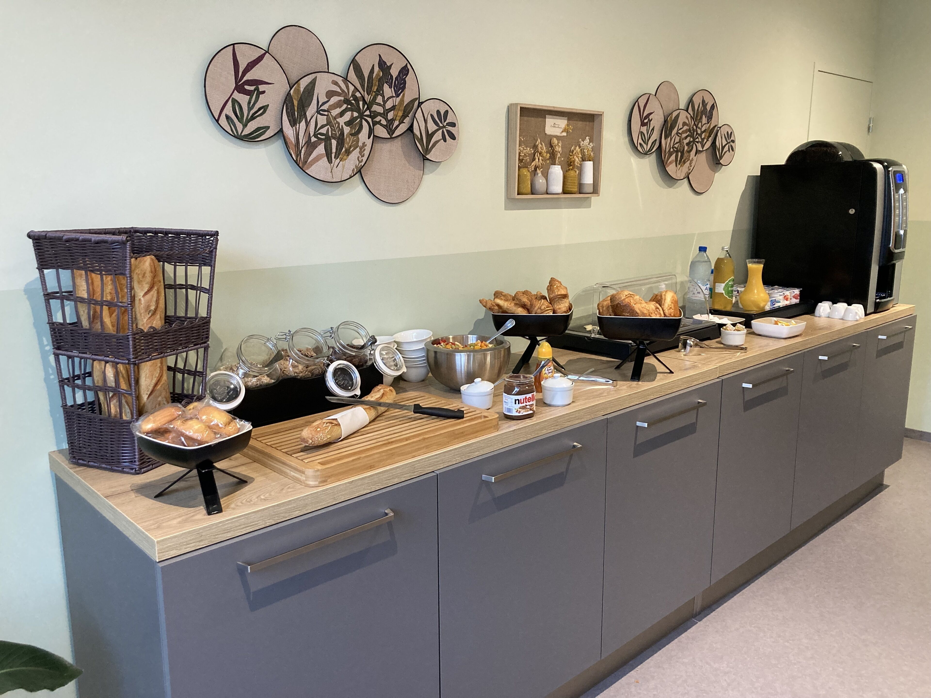 A buffet setup with bread, pastries, and condiments.