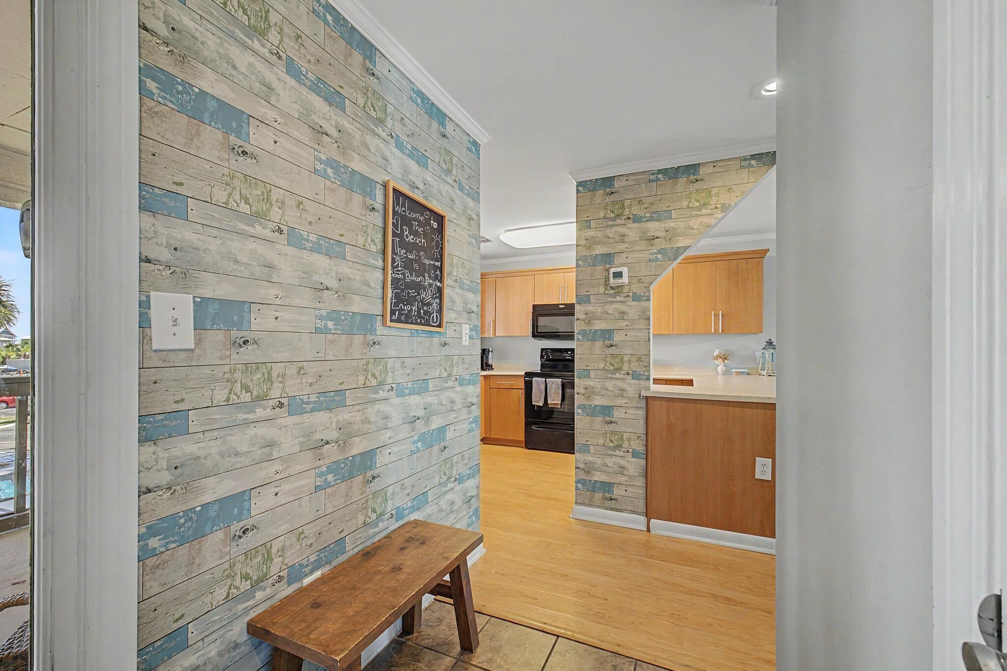 A modern kitchen with wooden cabinetry, a built-in oven, and a countertop with a vase.