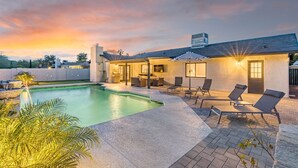 Ett modernt hus med en swimmingpool, utomhusmöbler och en uteplats.