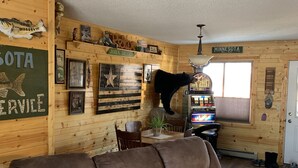 A cozy room with a large brown sofa, wooden walls, and a sign reading "MINNESOTA". - Beautiful sunsets. Maple hills condo owners (Annandale)