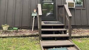 A wooden house with a front door, two windows, and a small porch with steps. - Beautiful sunsets. Maple hills condo owners (Annandale)