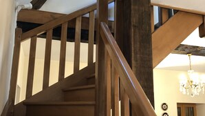 Una escalera de madera con barandilla que lleva a un piso superior.