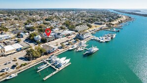 An aerial view of a coastal town with a marina, residential buildings, and a clear blue sky. - Why Knot Getaway...Rooftop with WaterView!  Unit D (Beaufort)