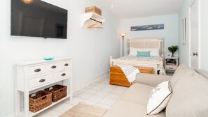 A bedroom with a bed, a TV, a dresser, and a nightstand. - Why Knot Getaway...Rooftop with WaterView!  Unit D (Beaufort)