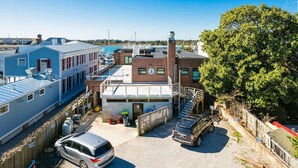 A parking lot with a building that has a clock on the side, a tree, and a truck. - Why Knot Getaway...Rooftop with WaterView!  Unit D (Beaufort)