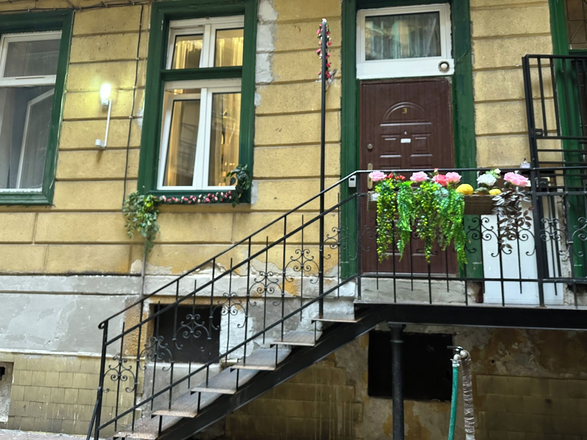 Un immeuble à plusieurs étages avec un escalier apparent menant à un étage supérieur.