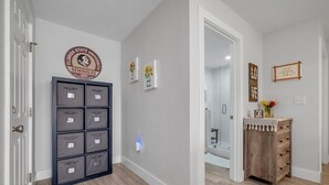 Un couloir avec une enseigne fixée au mur représentant l’équipe des Seminoles de l’université d’État de Floride, un luminaire fixé au mur et un meuble en bois doté de tiroirs.