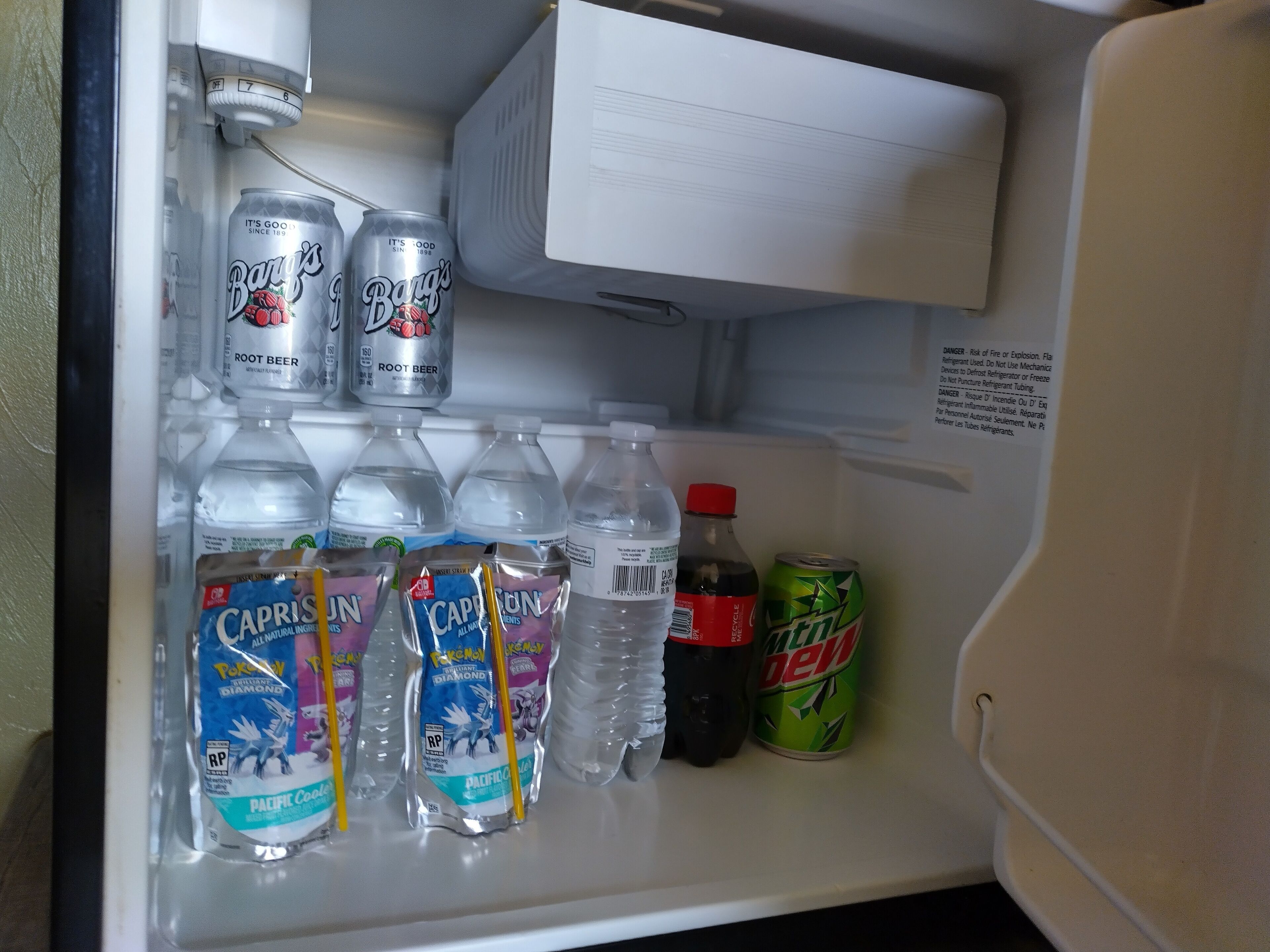 Un réfrigérateur rempli de boissons, notamment de bière de racine, d’eau et de Mountain Dew.