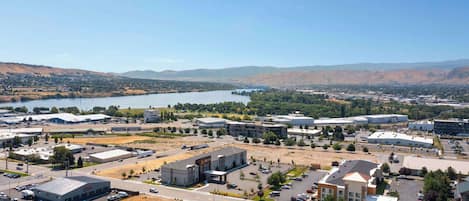 An aerial view of a commercial area with buildings, roads, and a lake.