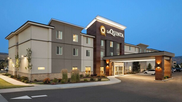 A La Quinta hotel with a modern design, featuring a large entrance, multiple windows, and a well-lit facade. - La Quinta Inn & Suites by Wyndham Wenatchee (Wenatchee)