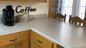 Una cocina con armarios de madera, una cafetera y una cesta en la encimera.