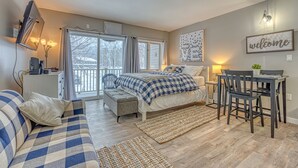 Ein gemütliches Schlafzimmer mit Bett, Sofa, Schreibtisch und Essecke.