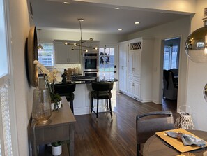 A modern kitchen with a central island, stainless steel appliances, and a dining area with a table and chairs.