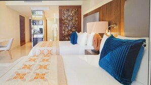 Een hotelkamer met een bed, nachtkastje, stoel en bureau. Ook een garderobe, spiegel en decoratiereseraam is te zien.
