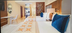 A hotel room with a bed, bedside table, chair, and a desk. There is a wardrobe, a mirror, and a decorative screen. - Two Bedroom Spacious Ocean Front in Cabo (San José del Cabo)