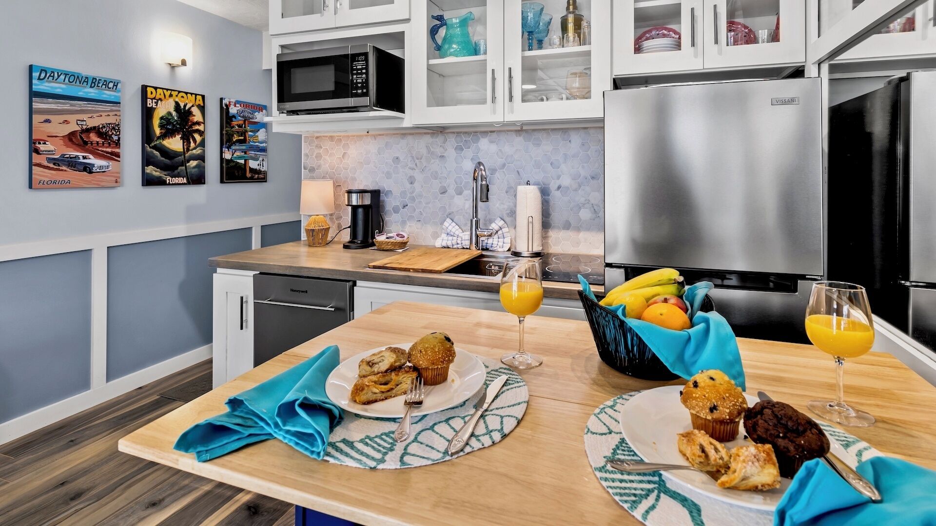 Una cocina moderna con microondas, refrigerador y un comedor con mesa lista para el desayuno.