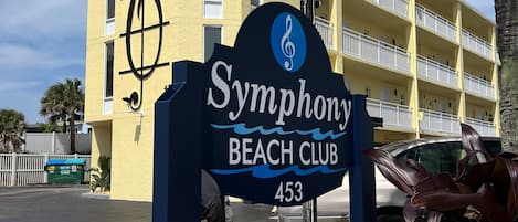 Une enseigne indiquant l’emplacement du Symphony Beach Club, avec un bâtiment en arrière-plan.