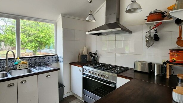 A modern kitchen with a stove, oven, and hanging lights.