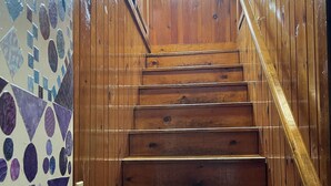 Eine Holztreppe mit Handlauf, die zu einer höheren Etage führt.