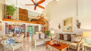 A spacious living area with a high ceiling, a wooden staircase, and a view of the kitchen. - (4323) 1 Br Hanalei Bay Resort, Ocean view and Plenty of Amenities (Princeville)