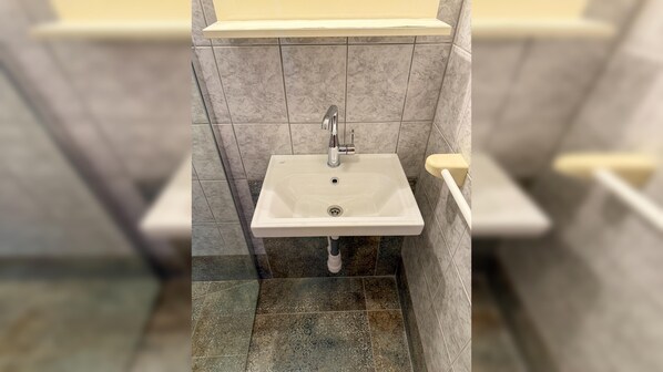 A bathroom with a white sink, a mirror, and a toilet.
