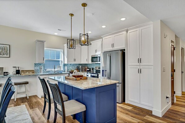 A modern kitchen with white cabinets, a blue island, and stainless steel appliances. - Enjoy Arcade Games! Ski Ball, Shuffleboard, Air Hockey, Dart Board, Hot Tub & Cmty Pools (Hollister)