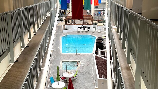 Et flerniveau-område med indendørs swimmingpool, inklusive en stor pool, mindre pools og et siddeområde med borde og stole.