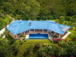 A large house with a swimming pool, surrounded by lush greenery. - Casa Blanca Ocean View 3 Suites (Ojochal)
