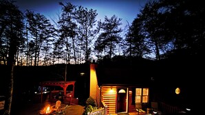 Une cabane dotée d’une terrasse, d’un foyer extérieur et d’un petit espace porche.