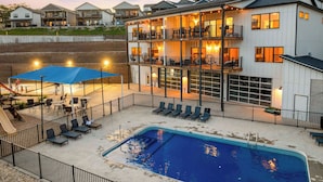 A multi-story hotel with outdoor seating and a swimming pool. - Unique Lakeview Home with Indoor Pool in Basement! (Branson)