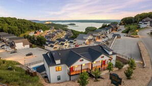 A hotel with a swimming pool, a parking lot, and a view of a lake. - Unique Lakeview Home with Indoor Pool in Basement! (Branson)