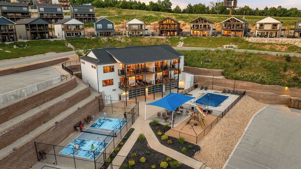 A multi-story building with a pool area, outdoor seating, and a basketball court. - Lake View! Indoor and Outdoor Pool! (Branson)