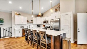 A modern kitchen with white cabinets, stainless steel appliances, and wooden flooring. - Lake View! Indoor and Outdoor Pool! (Branson)