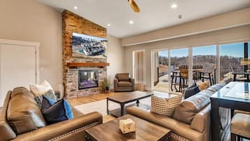 Televisión de pantalla plana, chimenea, libros y oficina