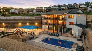 A multi-story building with a pool, outdoor seating, and a playground. - Lake View! Indoor and Outdoor Pool! (Branson)