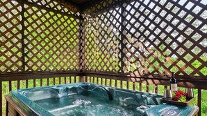 A hot tub with a wooden deck and lattice structure.